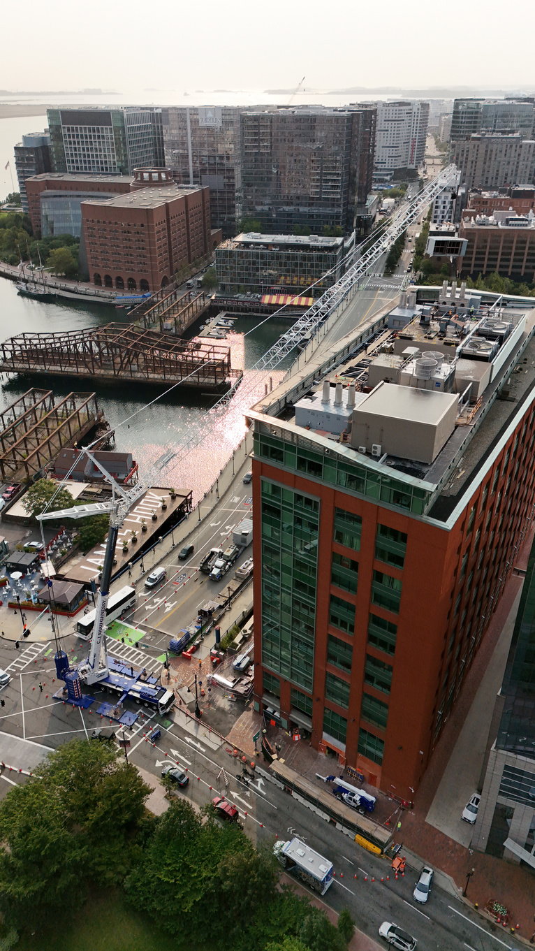 CJ Shaughnessy crane working the 470 Atlantic Avenue site, boom extended over the building beside Fort Point Channel